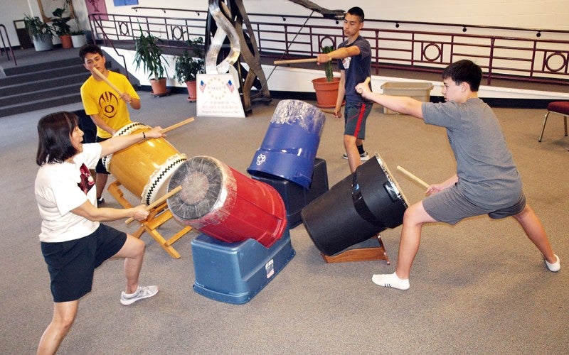 Janet and three of her students playing practice drums.